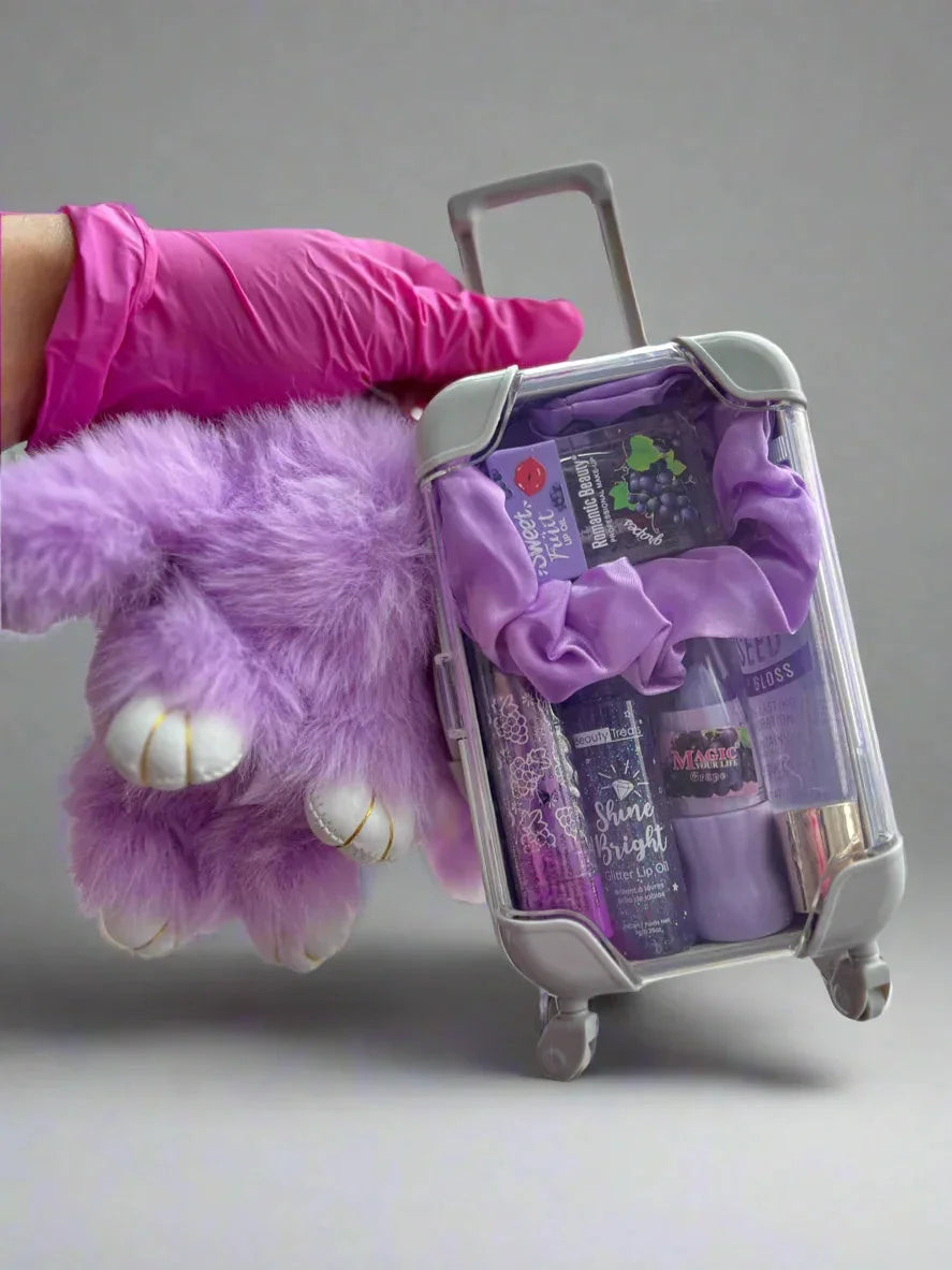 Purple plush toy holding a suitcase with purple items against a gray background