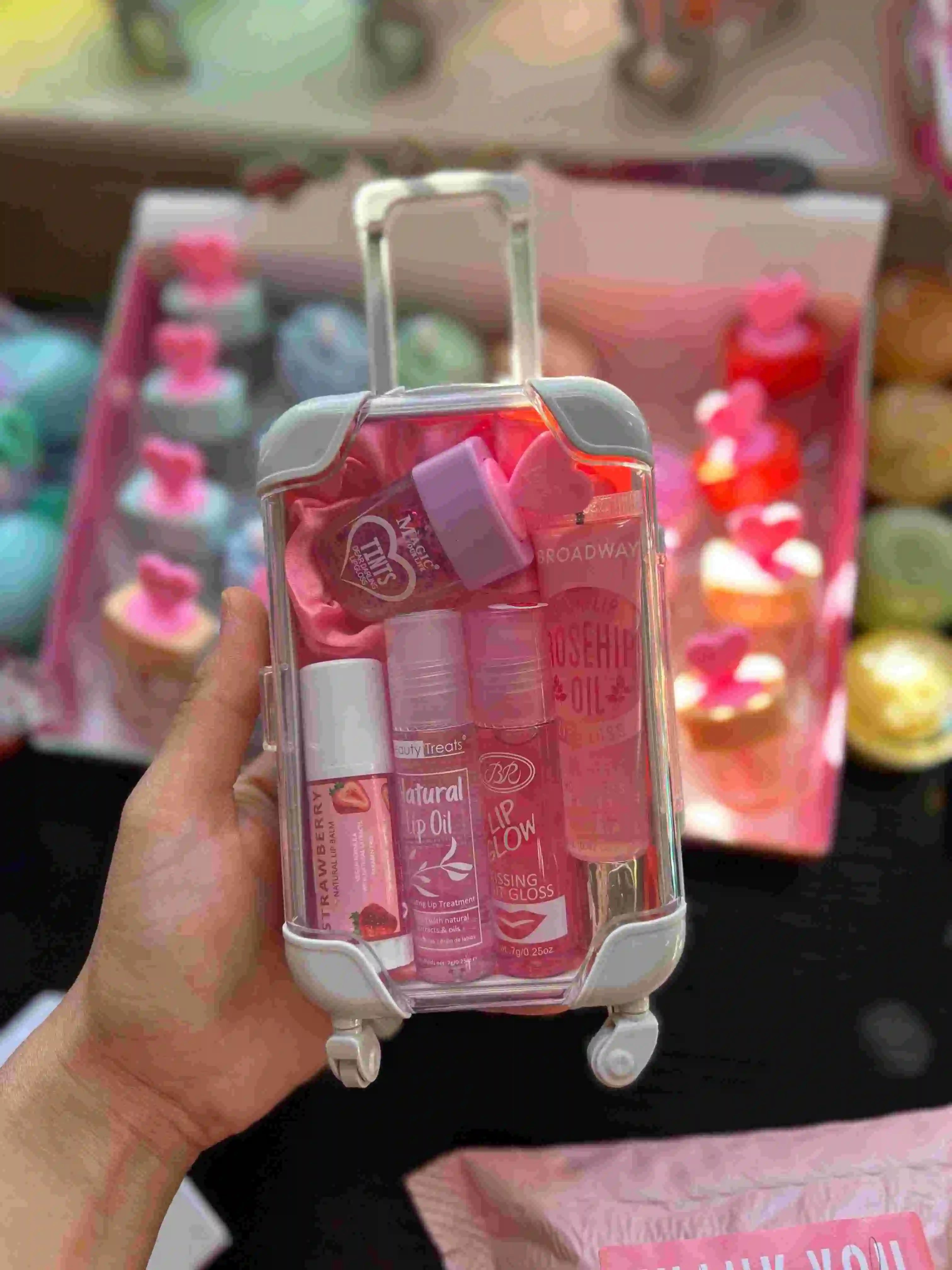 Set of lip products in a small suitcase-shaped holder with a blurred background
