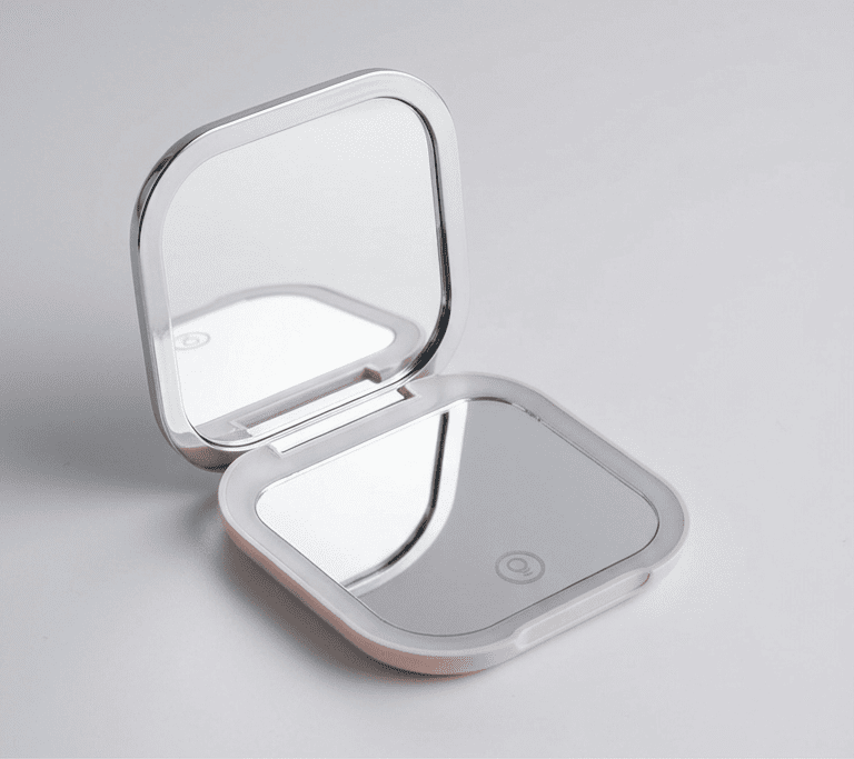 Compact mirror with LED lights on a gray background